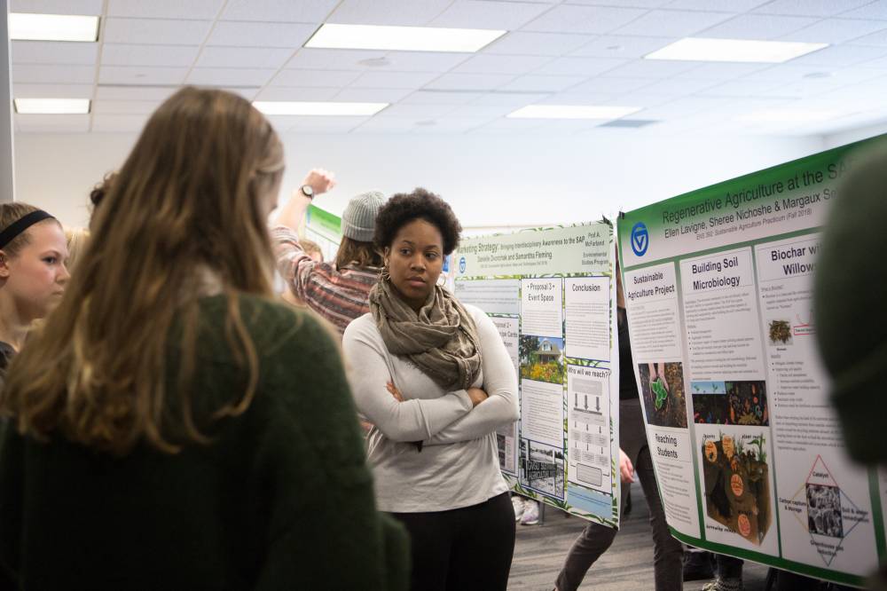 Attendees view a student group's poster presentation.